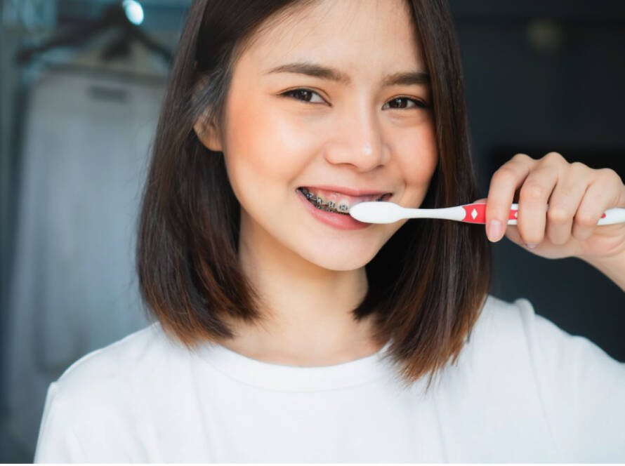 image orthodontics girl with braces brushing teeth
