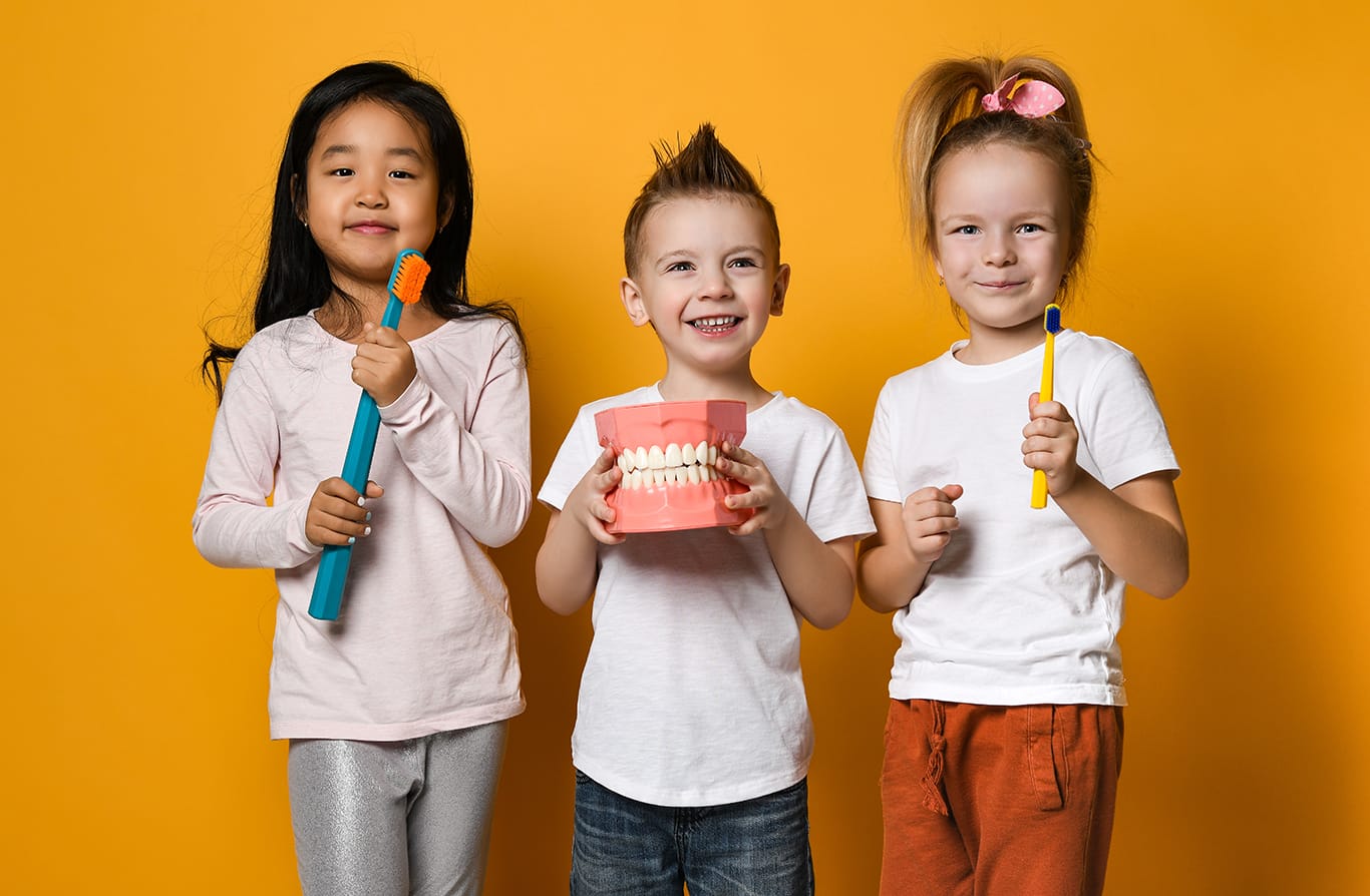 Three children with dental instruments