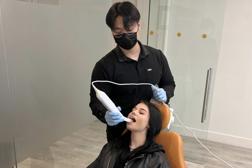 Learn about your first orthodontist appointment. A dentist performing a digital scan inside a young woman's mouth