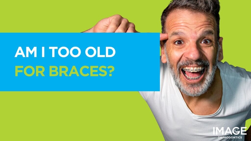 Older man, wearing metal braces, smiling.