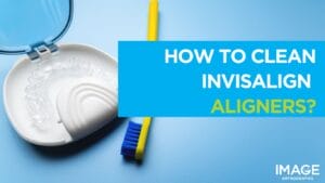 Clear Invisalign aligners in an open case next to a toothbrush