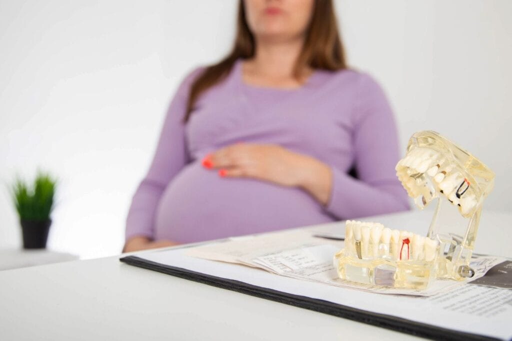 braces while pregnant, woman at an orthodontist appointment discussing braces, with dental models on the desk