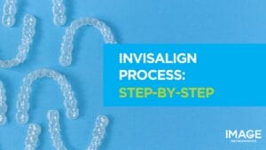 Clear Invisalign aligners arranged on a blue background.