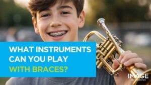 Smiling teenage boy with braces holding a trumpet outdoors