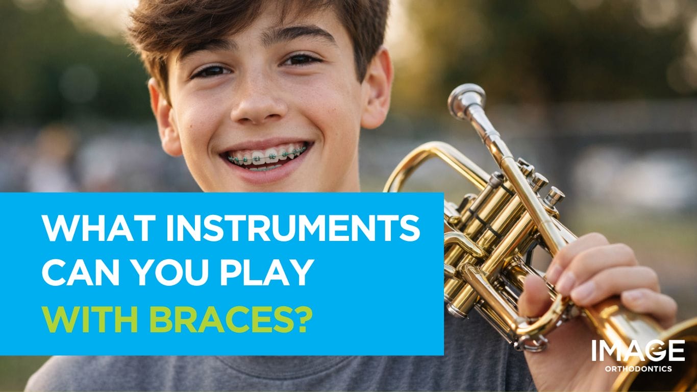 Smiling teenage boy with braces holding a trumpet outdoors